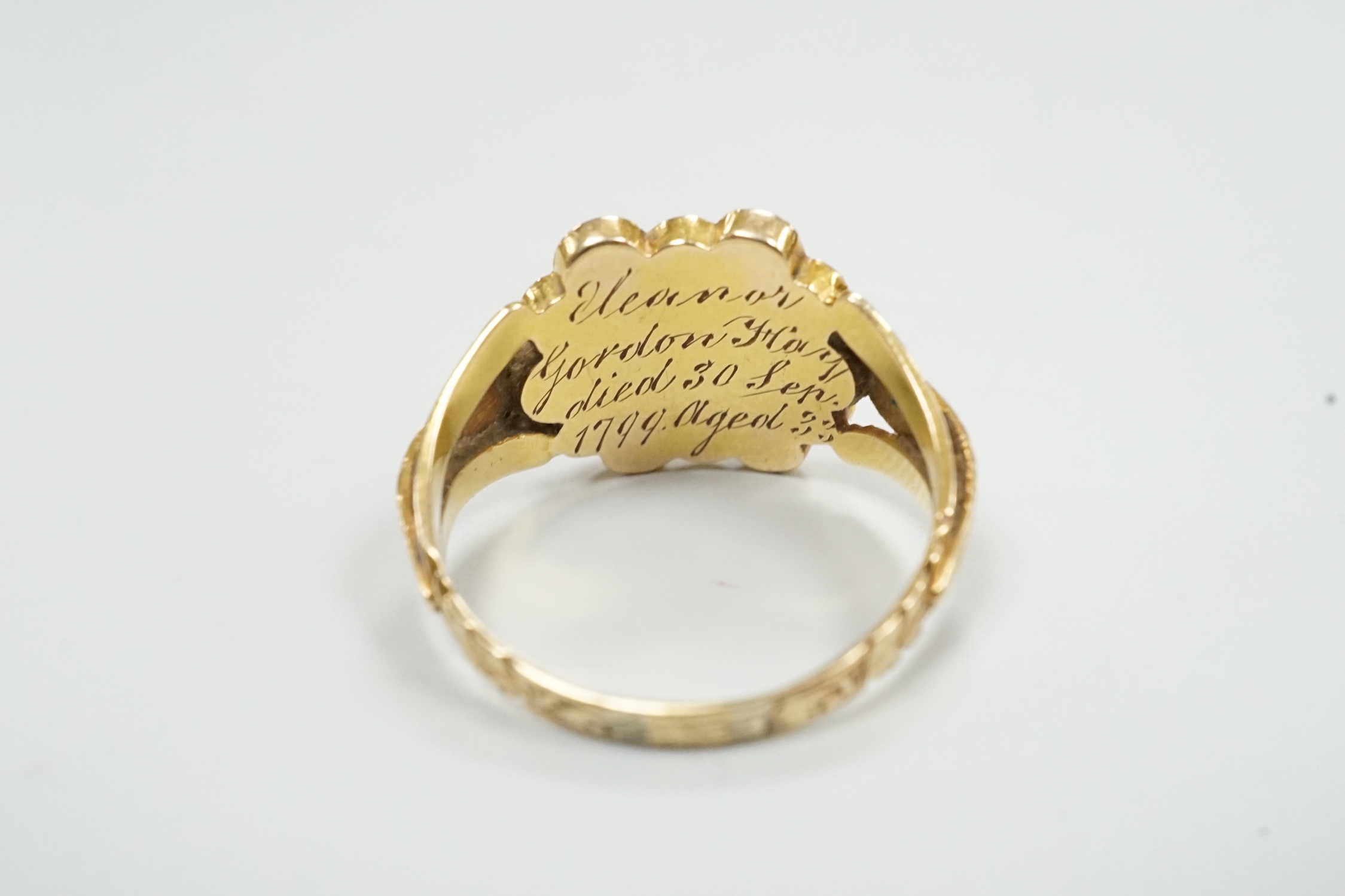 A George yellow metal, garnet and seed pearl cluster set mourning ring, with inscription dated 1799, size L, gross weight 2.7 grams.